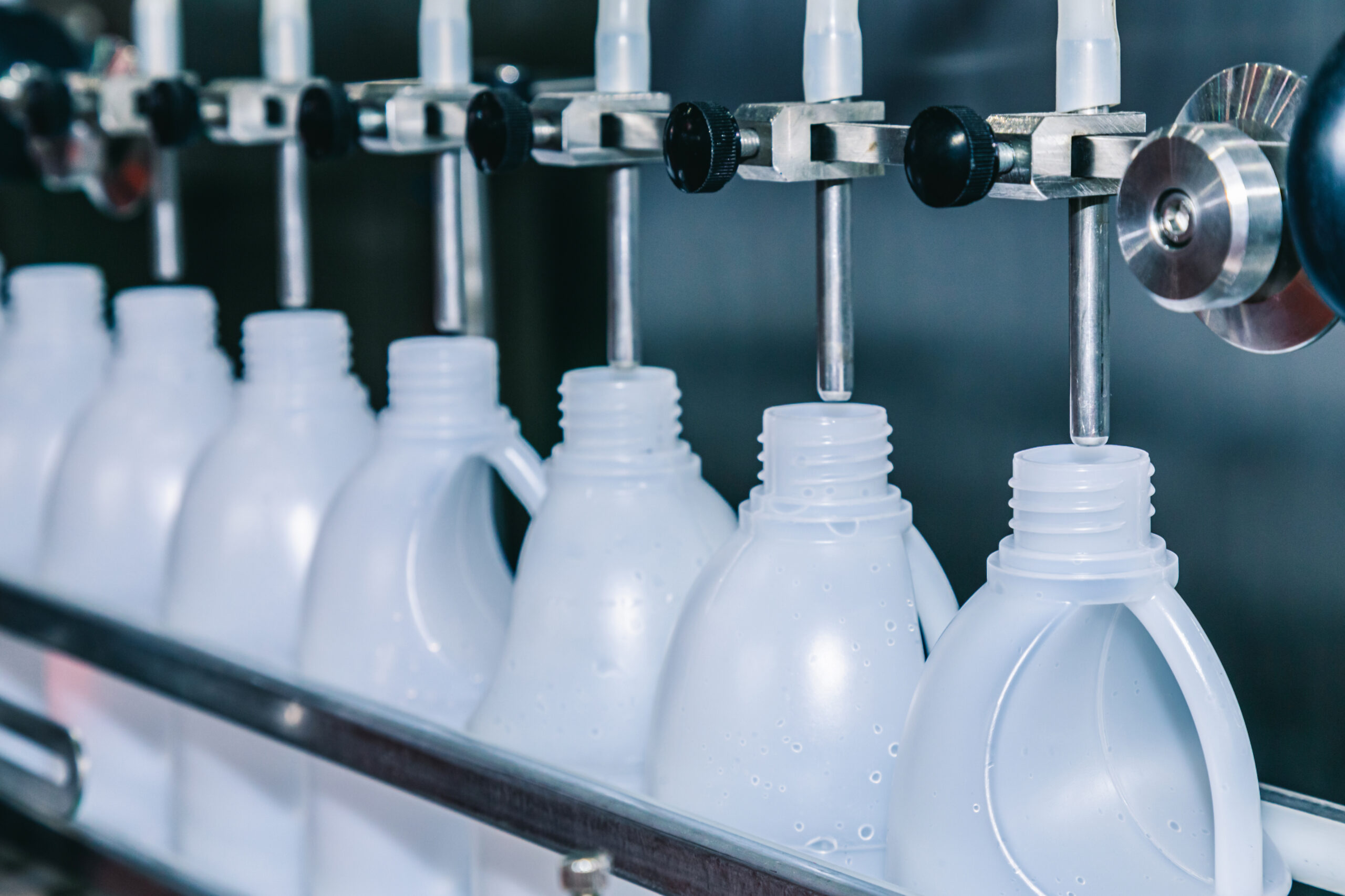 white plastic gallons or bottle on the production line of the co